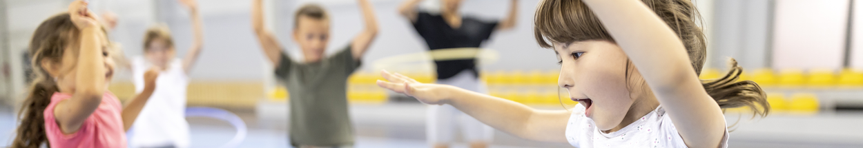 Jonge kinderen spelend in de gymzaal