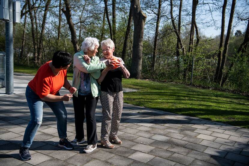 Foto van drie dames die samen buiten bewegen met een bal